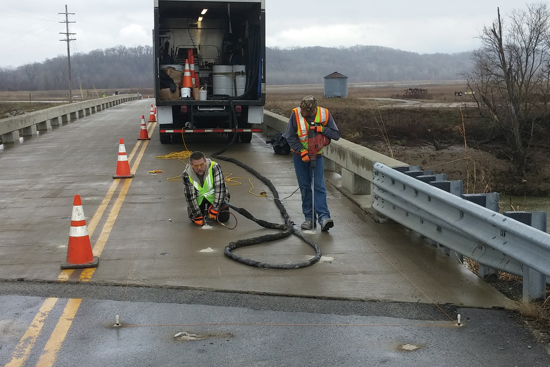 PolyPier concrete lifting foam being injected under the road on a bridge.